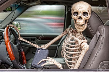 23213200-a-skeleton-behind-the-wheel-of-an-suv-distracted-by-his-cell-phone--he-is-also-not-wearing-a-seatbel